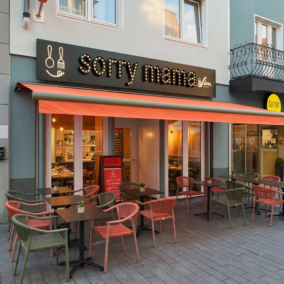 Terrasse von Sorry Mama mit orangefarbener Markise in der Kölner Innenstadt